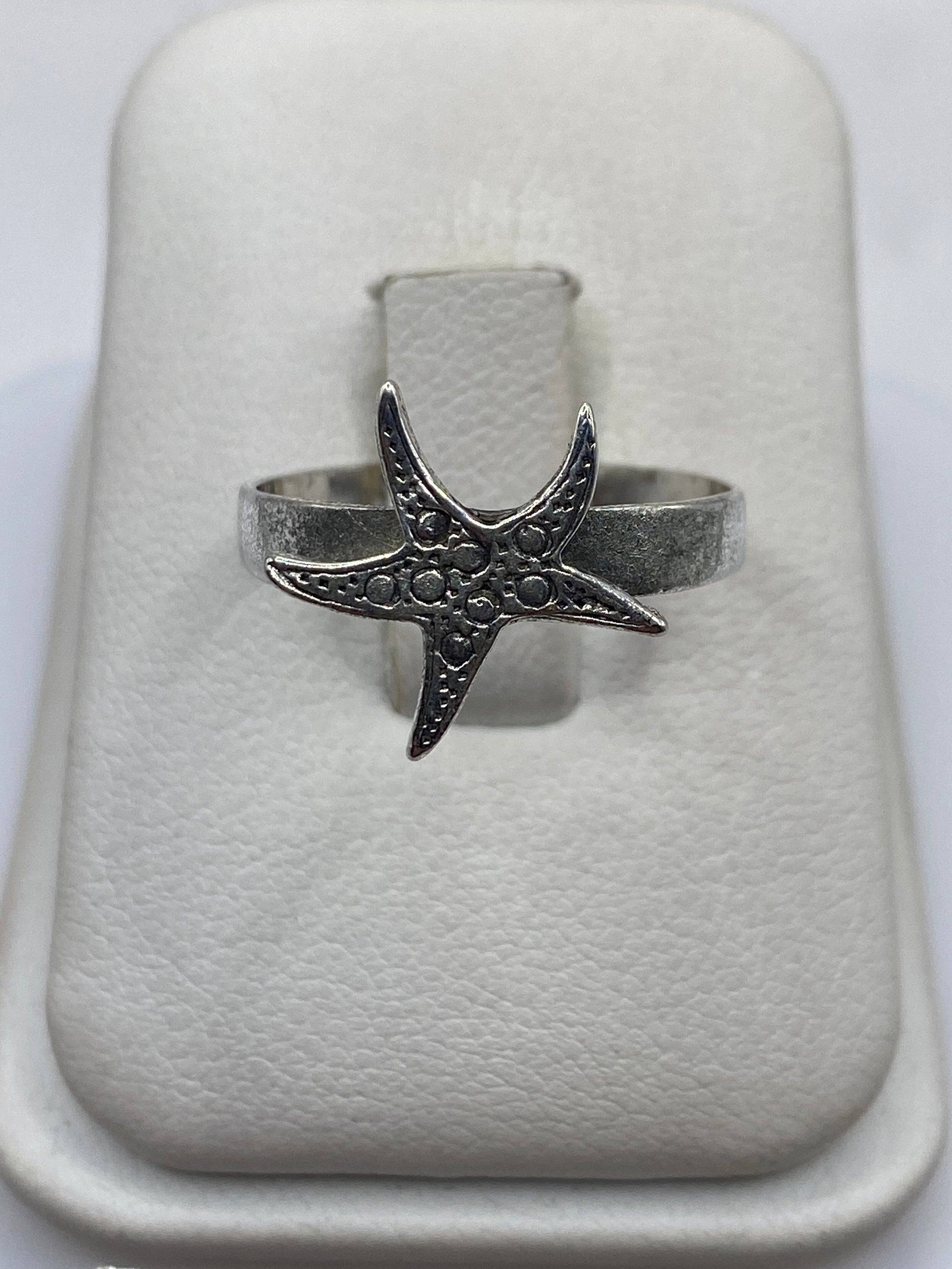 Anillo de plata con diseño de estrella de mar grabada en relieve, vista superior