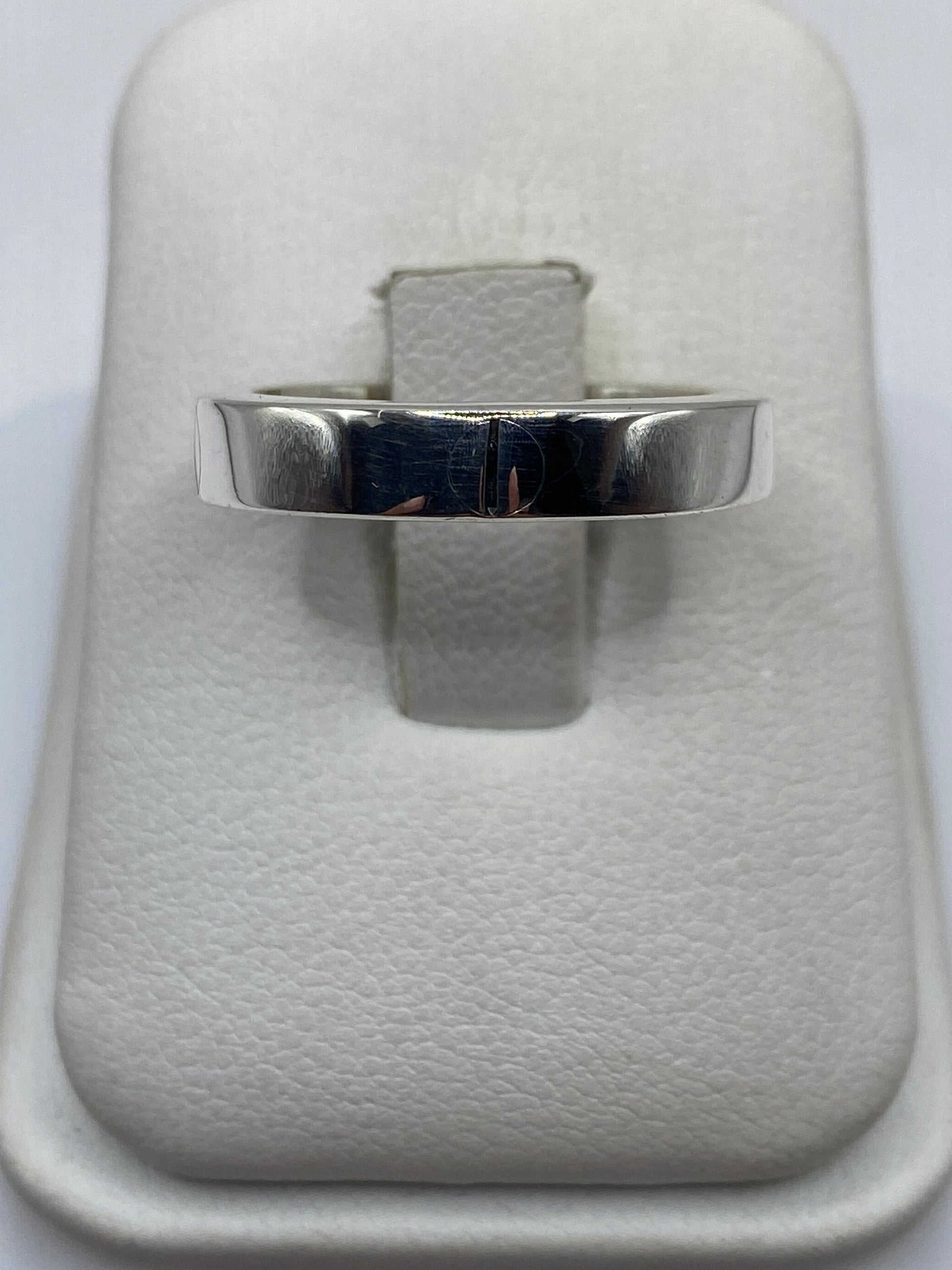 Anillo banda de plata .925 pulido en la mano, mostrando el brillo espejo del metal
