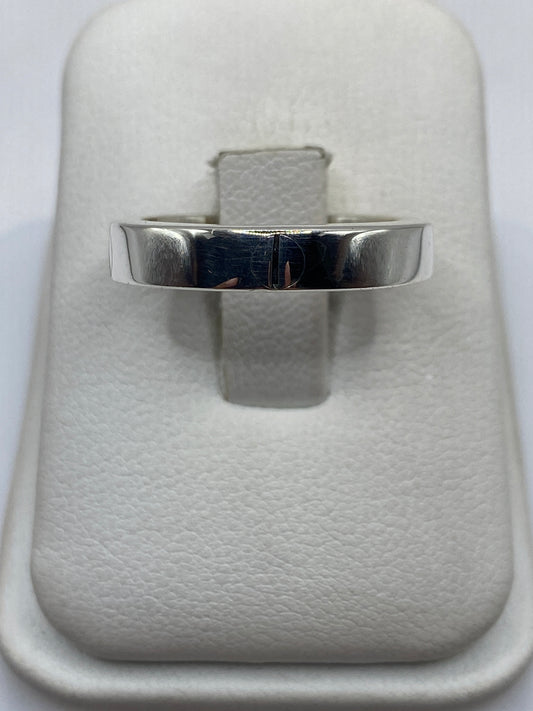 Anillo banda de plata .925 pulido en la mano, mostrando el brillo espejo del metal