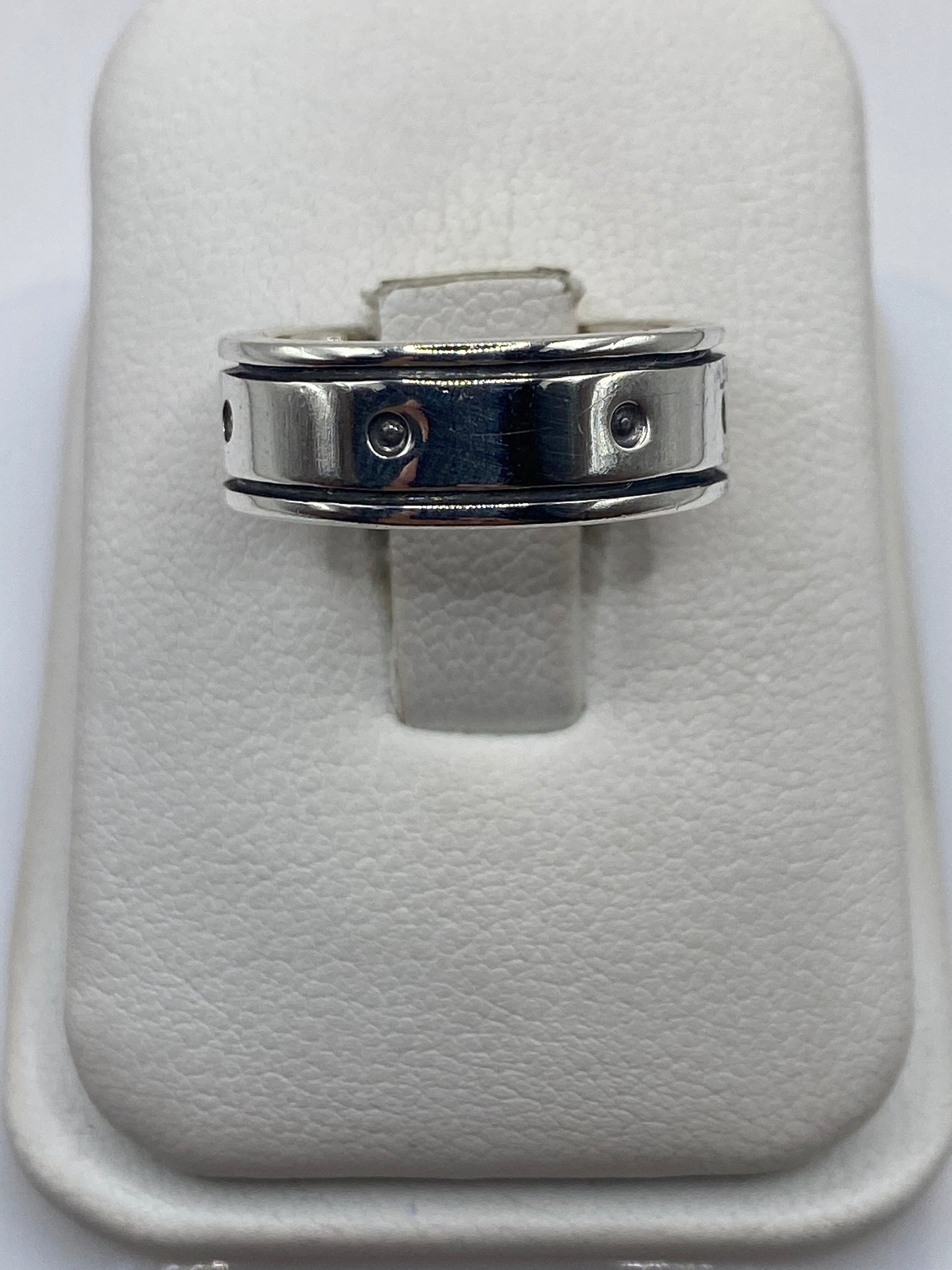 Anillo de plata banda perforada en mano mostrando el diseño geométrico minimalista