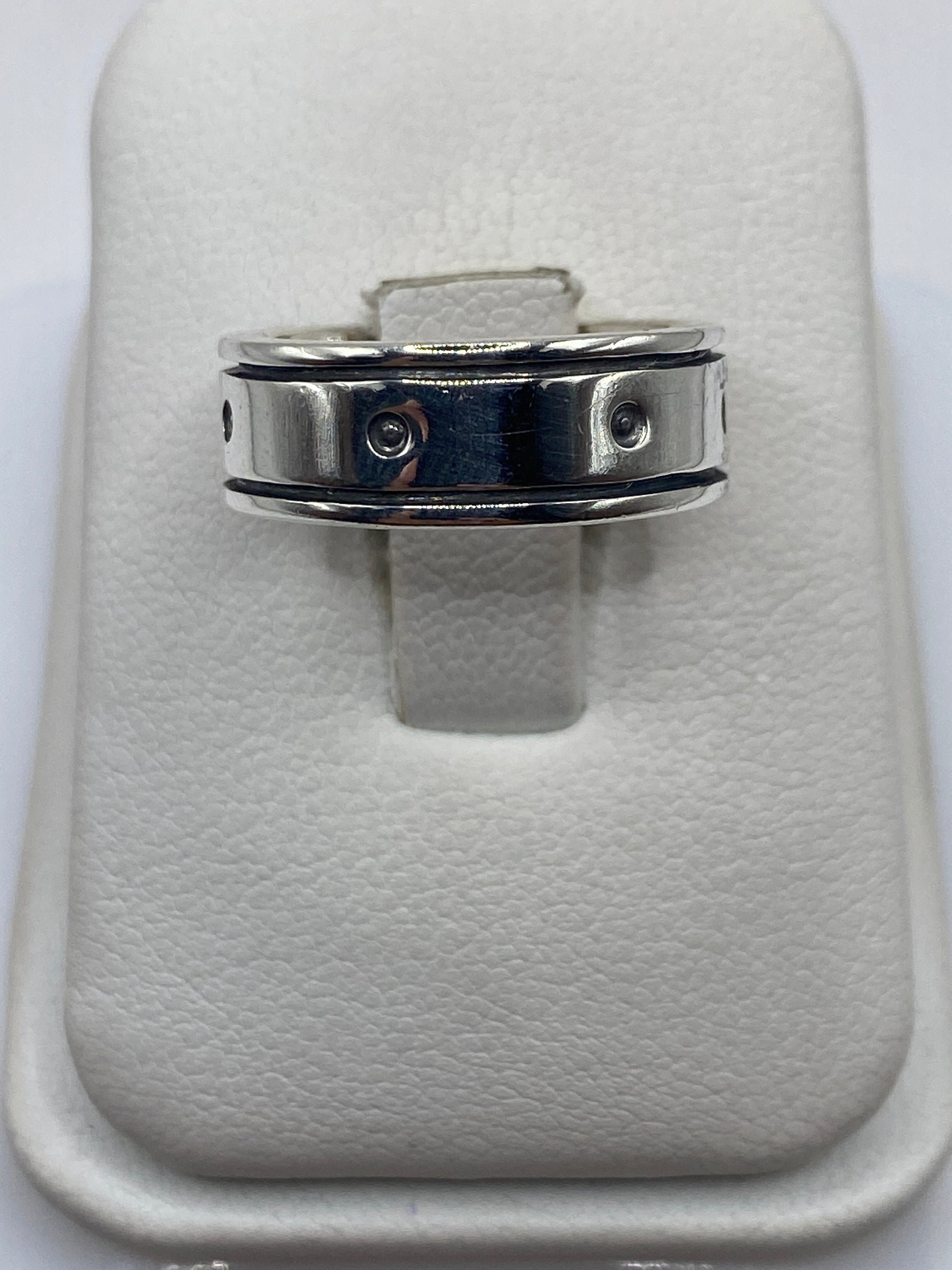 Anillo de plata banda perforada en mano mostrando el diseño geométrico minimalista