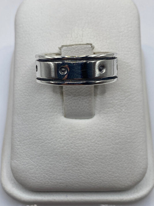 Anillo de plata banda perforada en mano mostrando el diseño geométrico minimalista