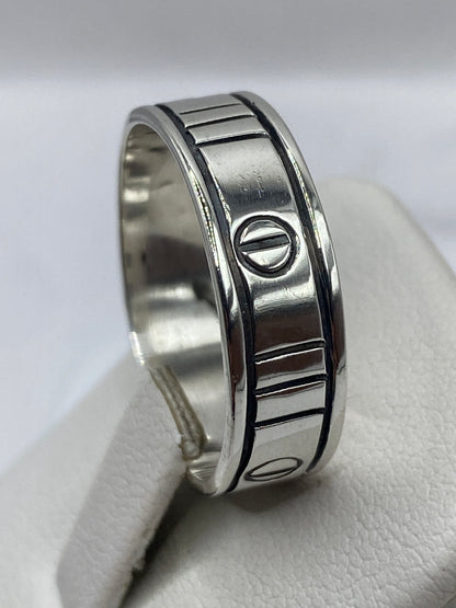Anillo sello de plata en la mano, luciendo presencia y peso