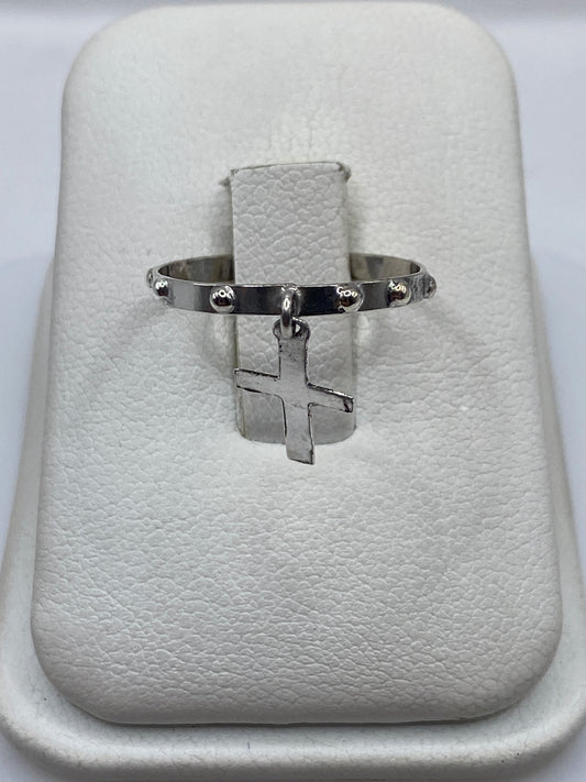 Anillo de plata .925 con cruz colgante minimalista en la mano de una persona