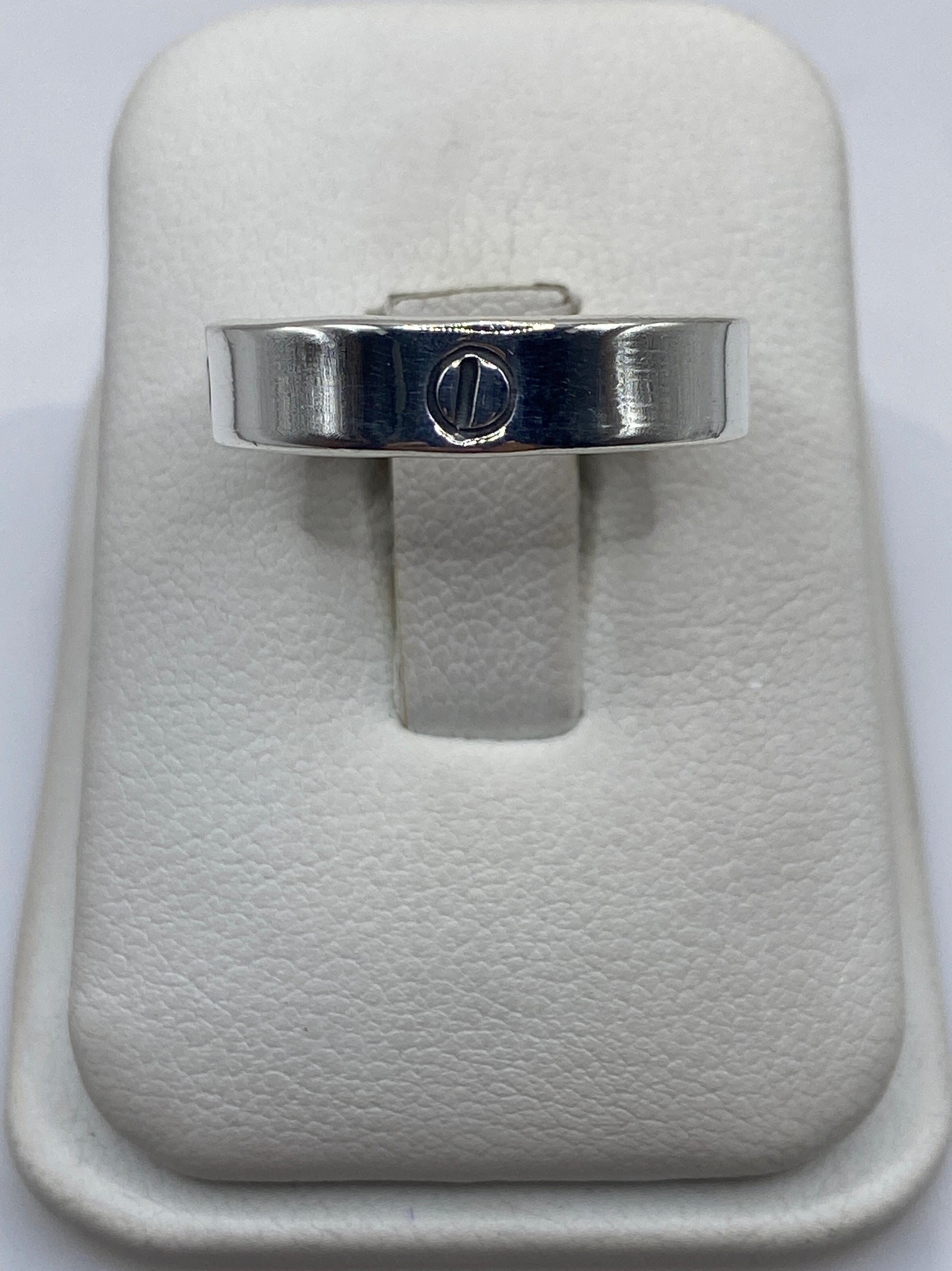 Anillo de plata banda lisa con sello grabado en la mano de una persona