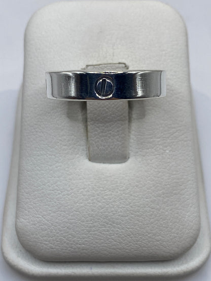 Anillo de plata banda lisa con sello grabado en la mano de una persona