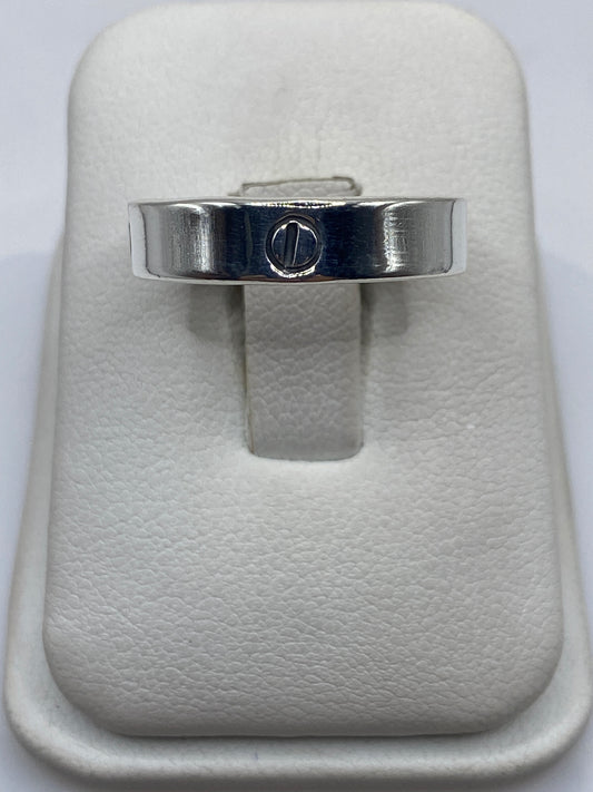 Anillo de plata banda lisa con sello grabado en la mano de una persona