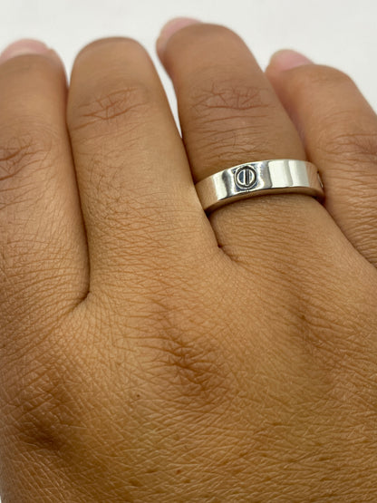 Anillo banda lisa de plata sobre fondo blanco mostrando el pulido artesanal
