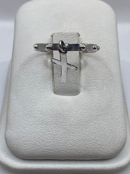 Anillo de plata .925 con cruz minimalista en la mano de un hombre