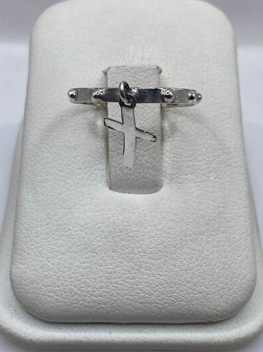 Anillo de plata .925 con cruz minimalista en la mano de un hombre