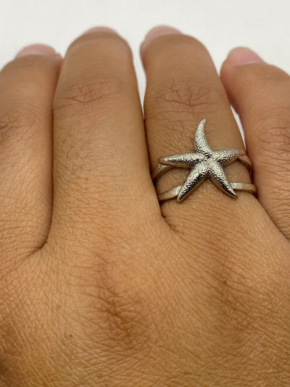 Anillo puesto en dedo mostrando la forma escultural en luz natural