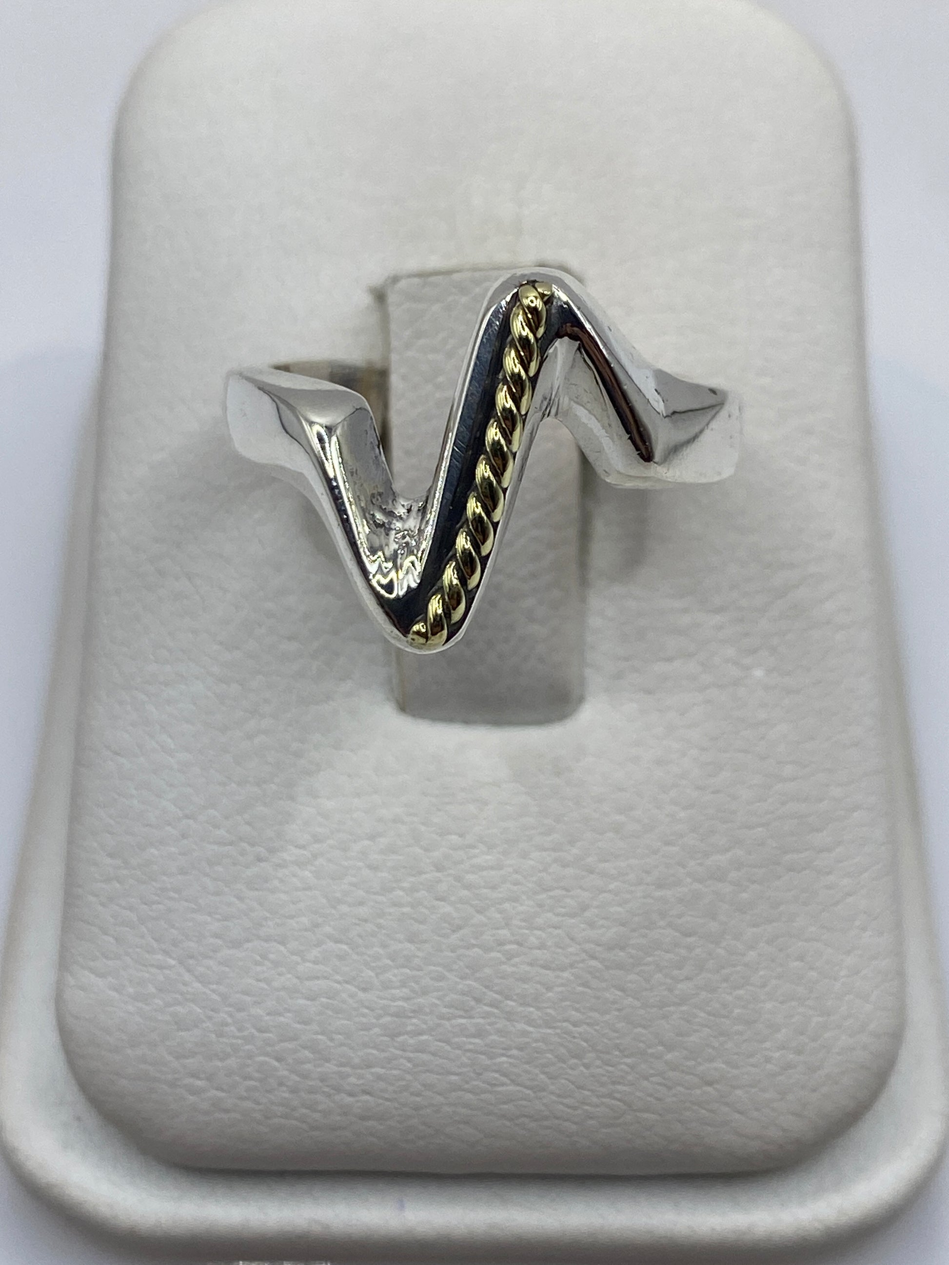 Anillo de plata onda minimalista en forma de V sobre fondo blanco