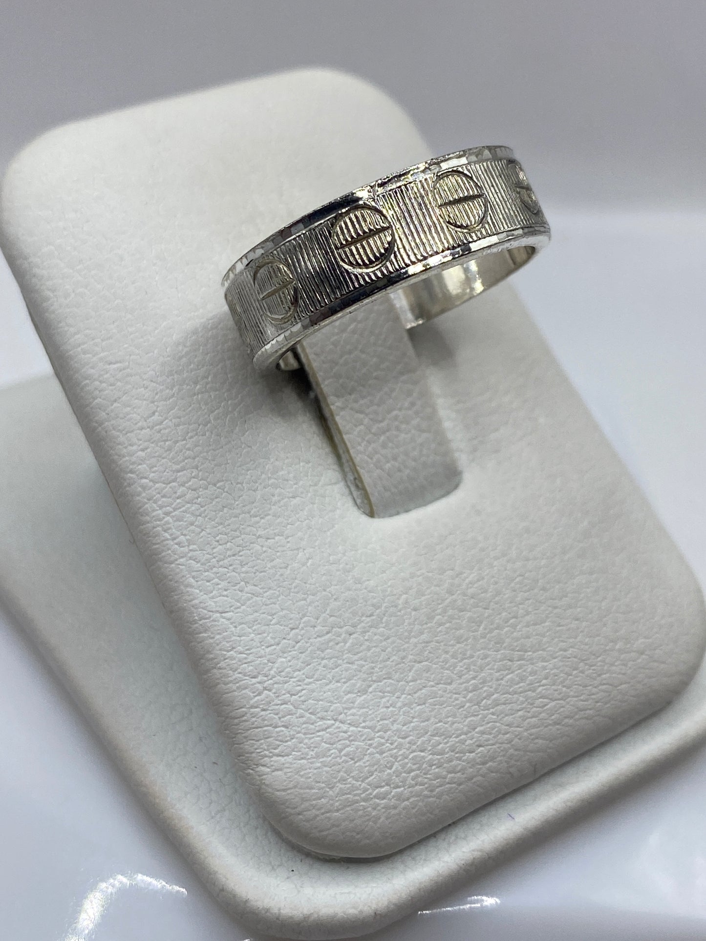 Vista frontal del anillo banda con textura geométrica en plata .925