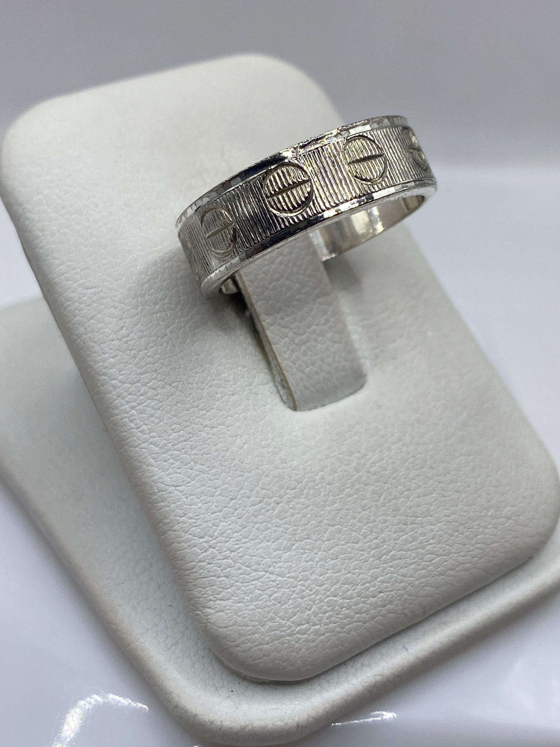 Vista frontal del anillo banda con textura geométrica en plata .925