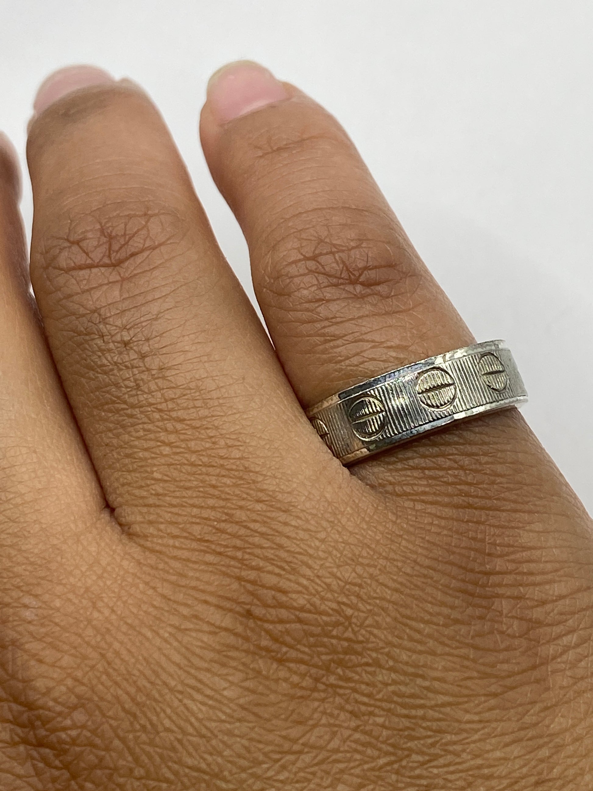 Anillo banda sobre superficie gris mostrando el sello 925 en el interior