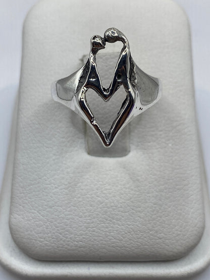Anillo de plata con diseño de manos en abrazo sobre fondo blanco