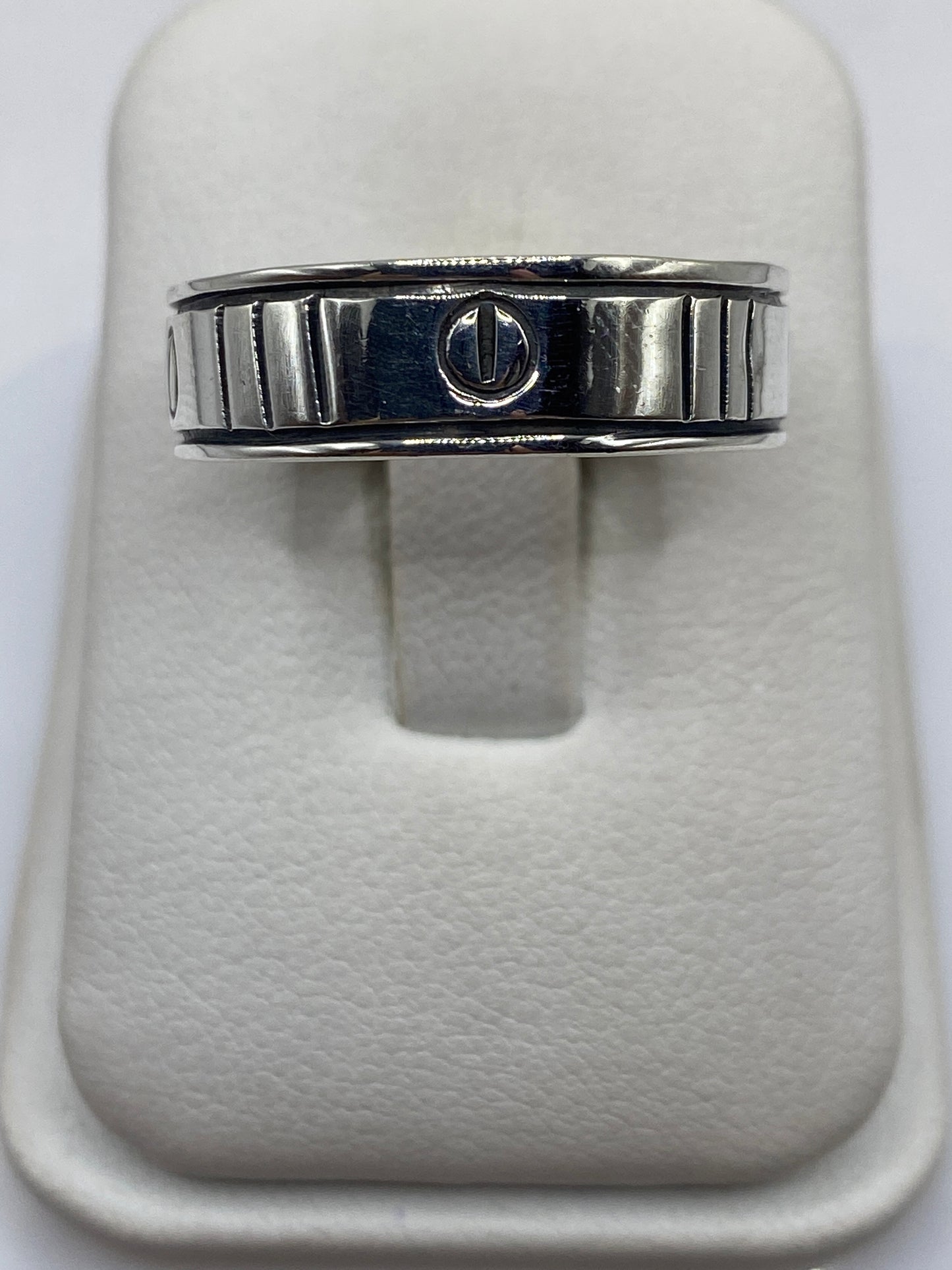 Anillo de plata sello con líneas arquitectónicas en dedo de hombre, vista frontal