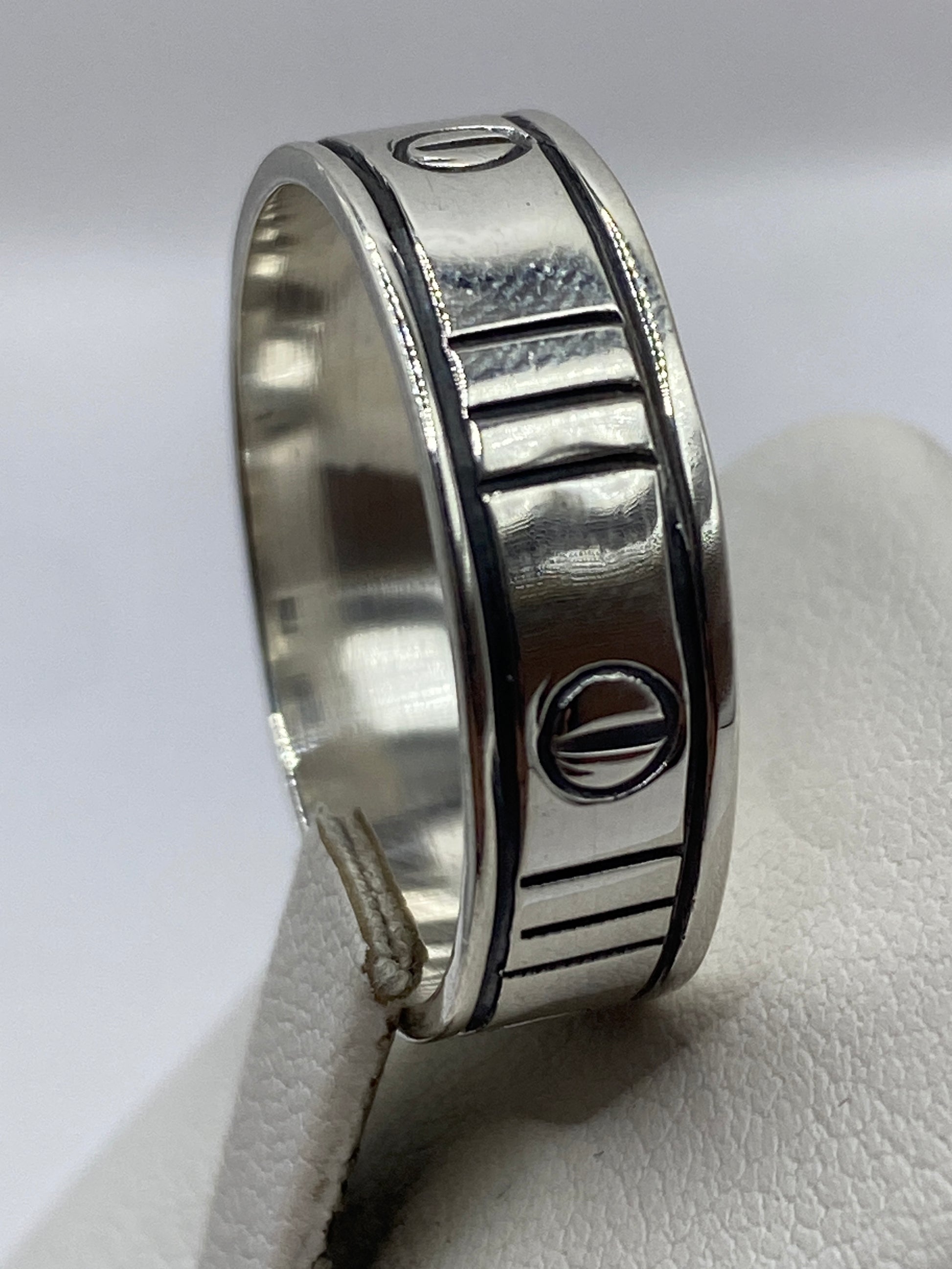 Anillo de plata macizo en la mano, vista lateral mostrando el peso y profundidad