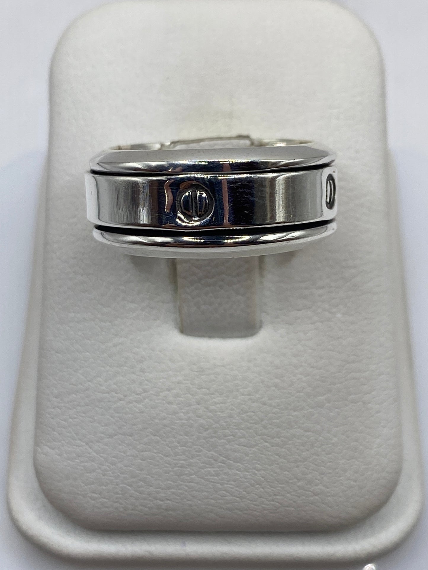Anillo de plata sello pulido en dedo masculino mostrando su presencia robusta