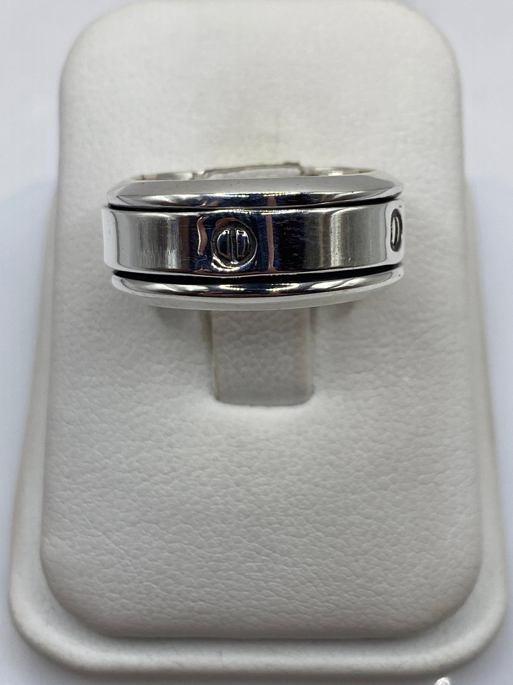 Anillo de plata sello pulido en dedo masculino mostrando su presencia robusta