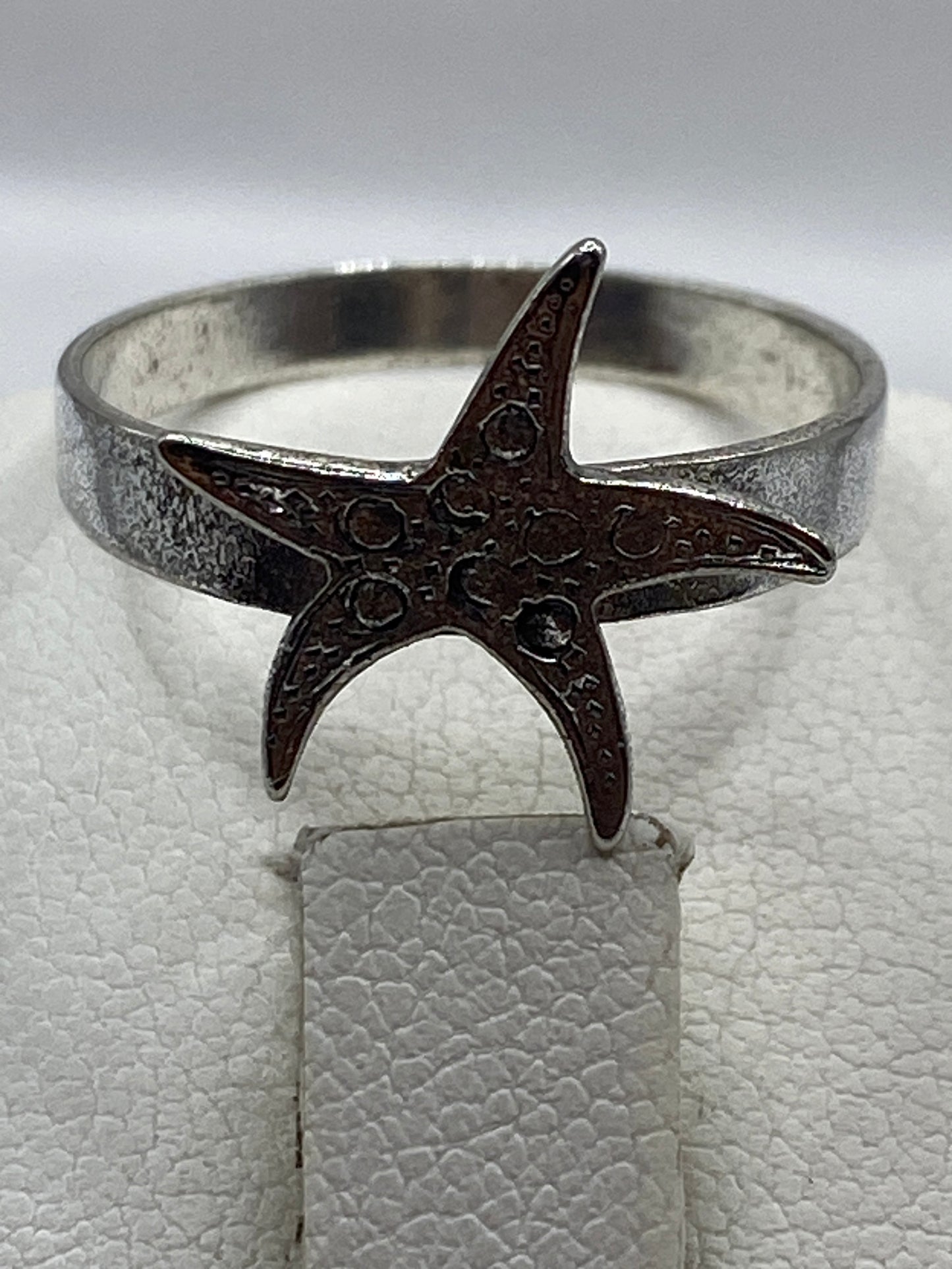Anillo de plata en dedo mostrando el diseño marino elegante