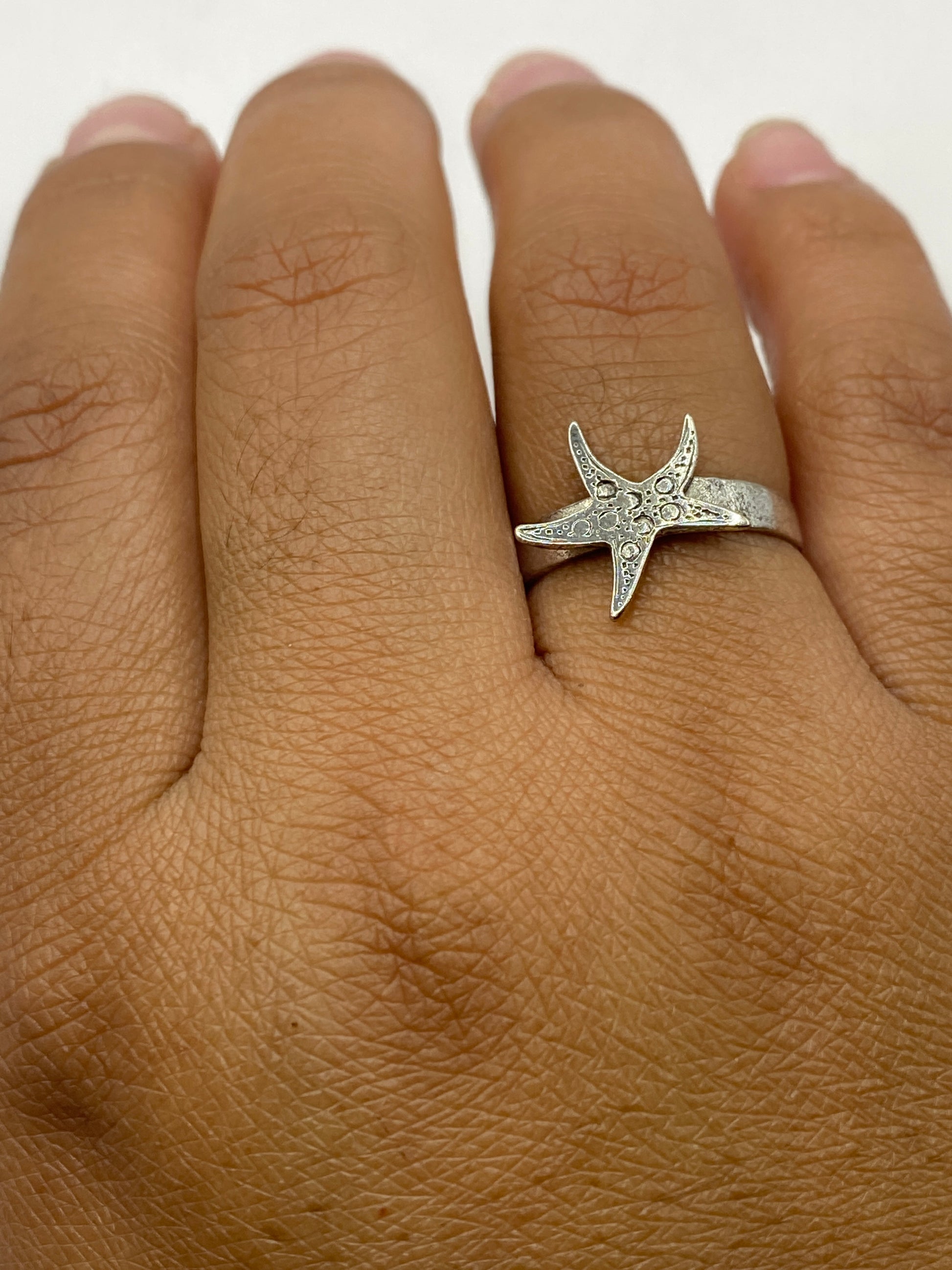 Anillo estrella de mar sobre fondo blanco con sello .925 visible