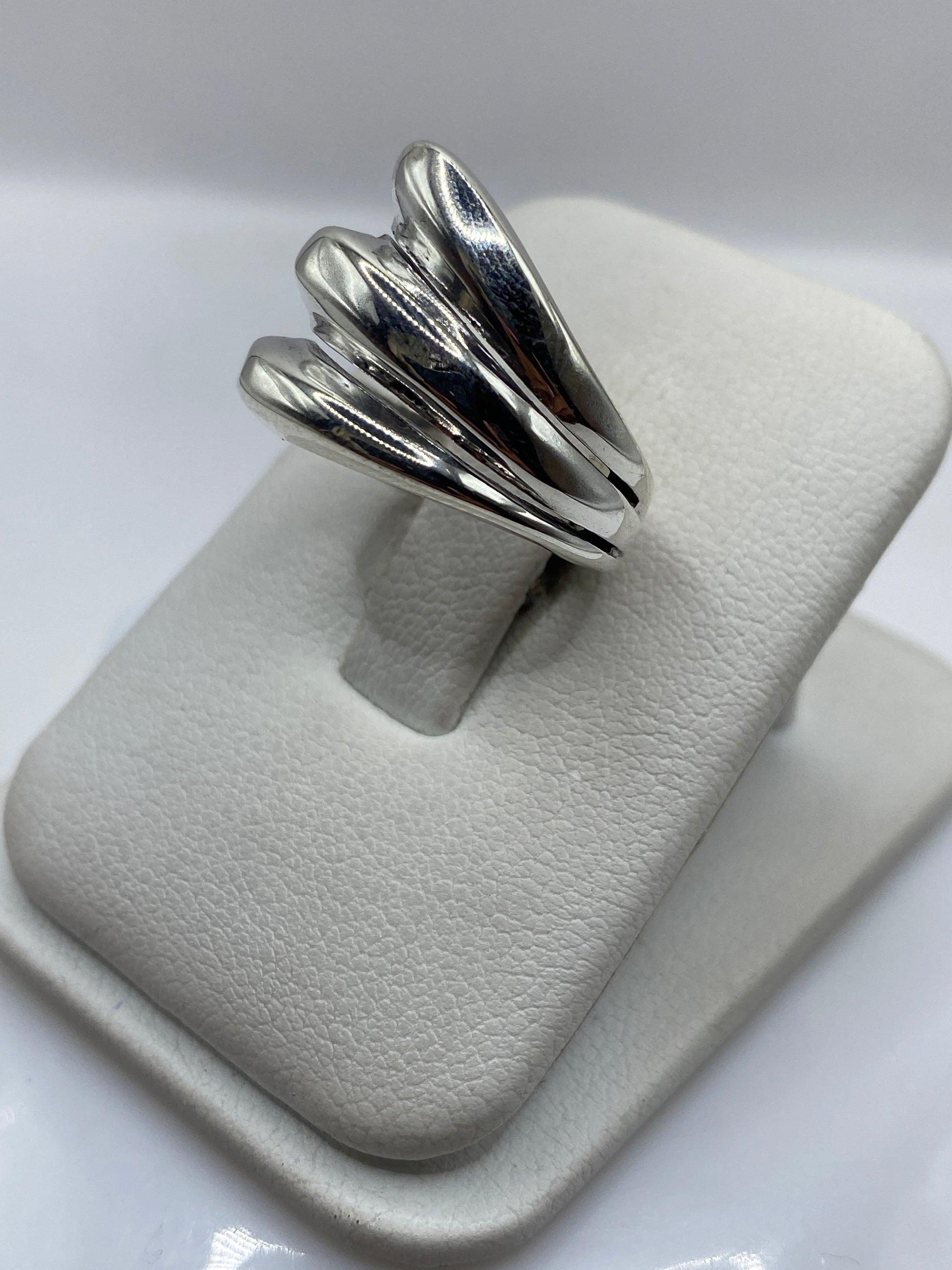 Anillo de plata pétalos en la mano de una mujer, mostrando textura y brillo pulido