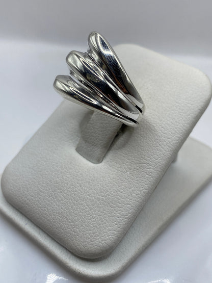 Anillo de plata pétalos en la mano de una mujer, mostrando textura y brillo pulido