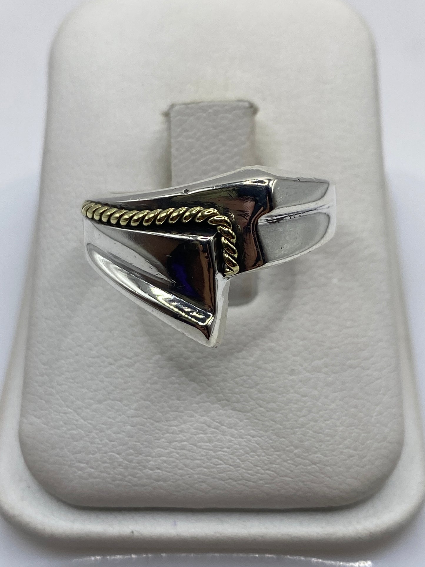 Anillo de plata retorcido minimalista en la mano de un hombre, vista frontal