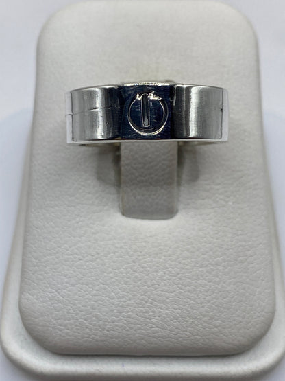 Anillo de plata con sello grabado, vista frontal en la mano de un hombre
