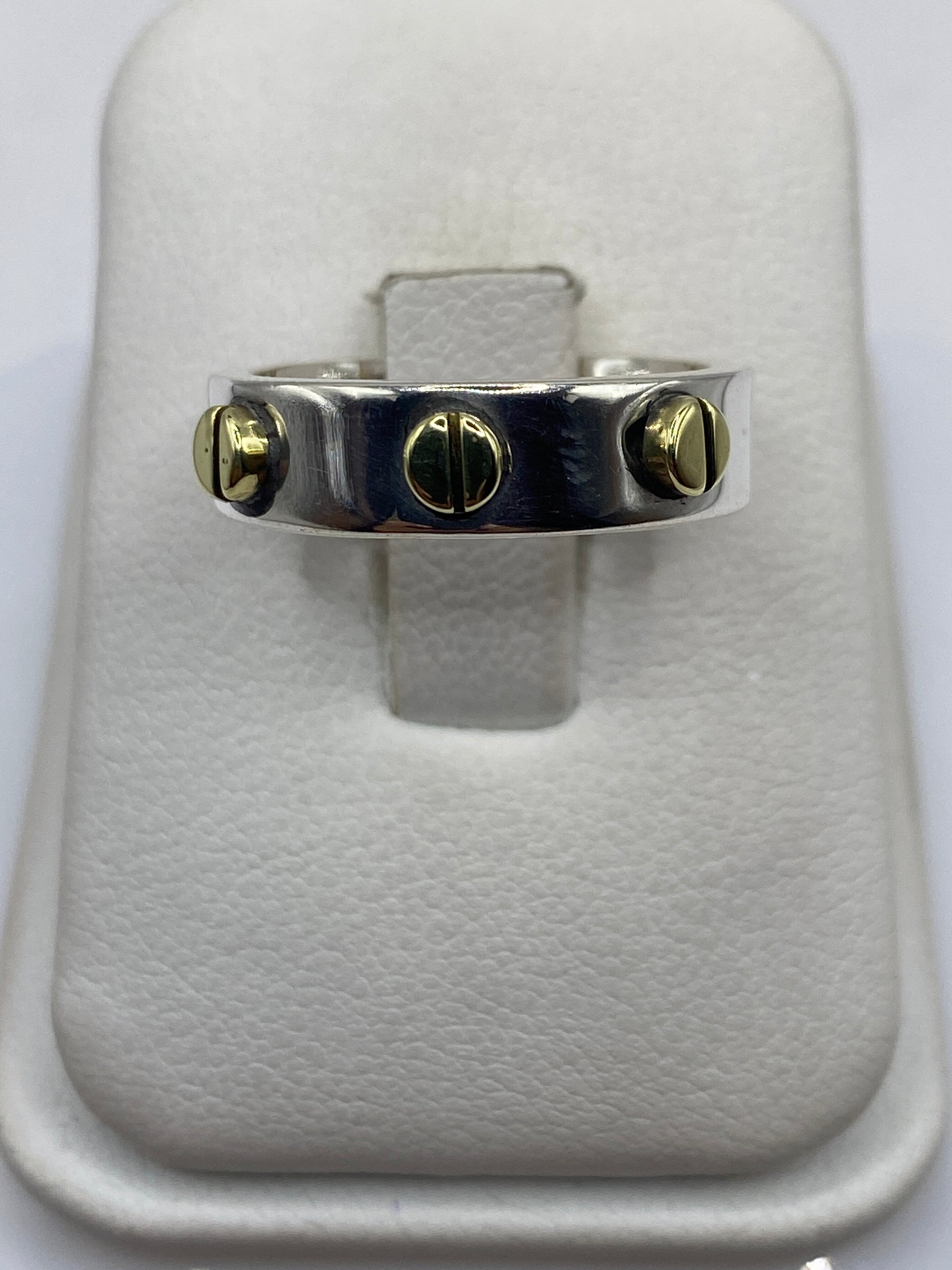 Anillo de plata sello con detalles dorados visto de frente sobre fondo blanco