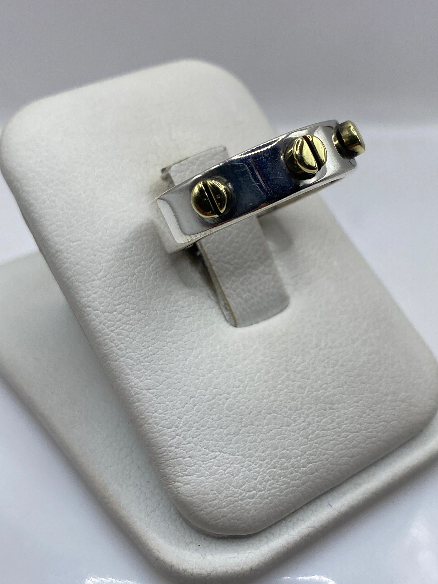 Anillo de plata maciza con banda de 8mm y detalles en oro, vista lateral sobre dedo