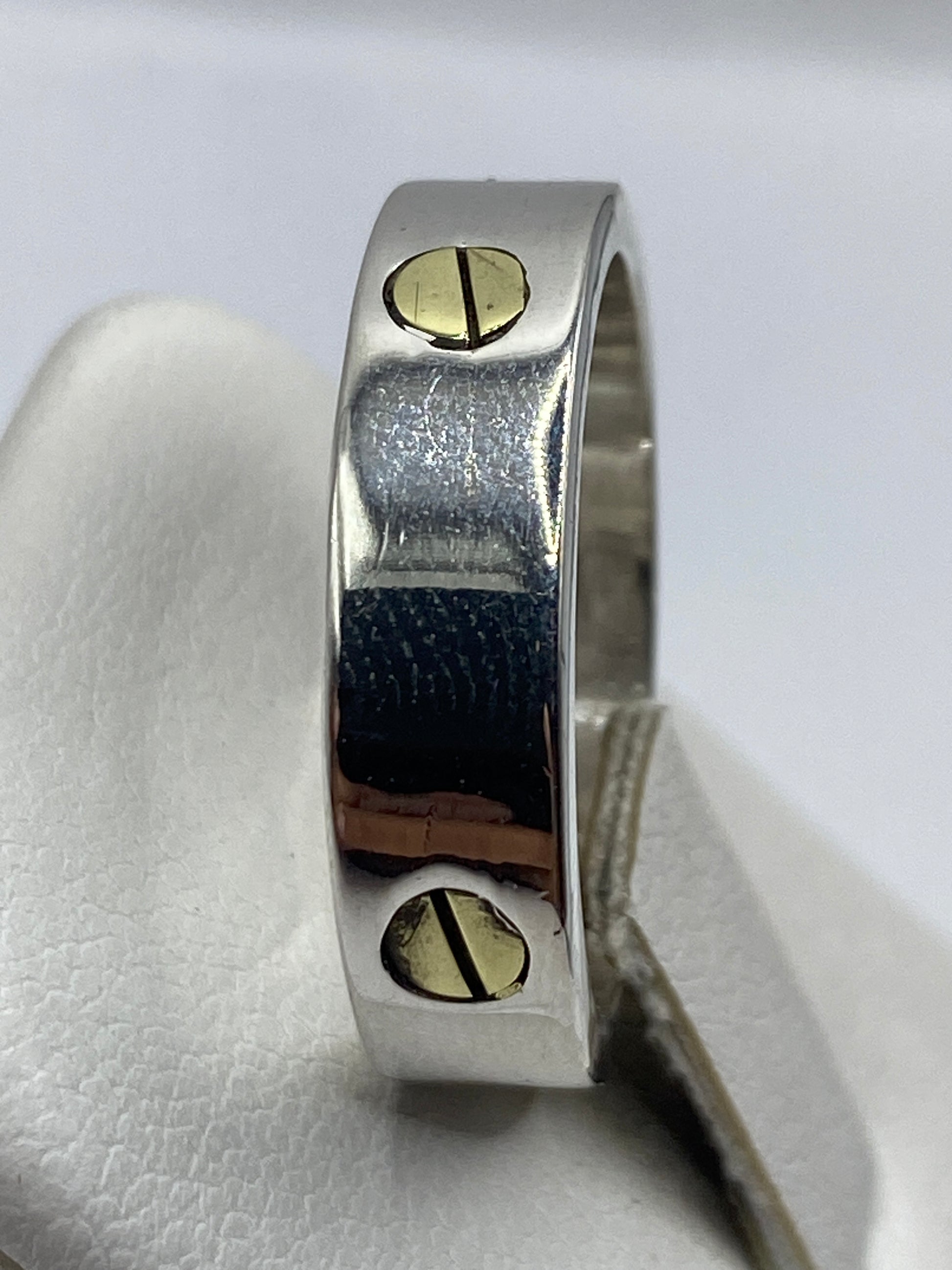 Anillo sello puesto en dedo masculino, presencia arquitectónica en oro y plata