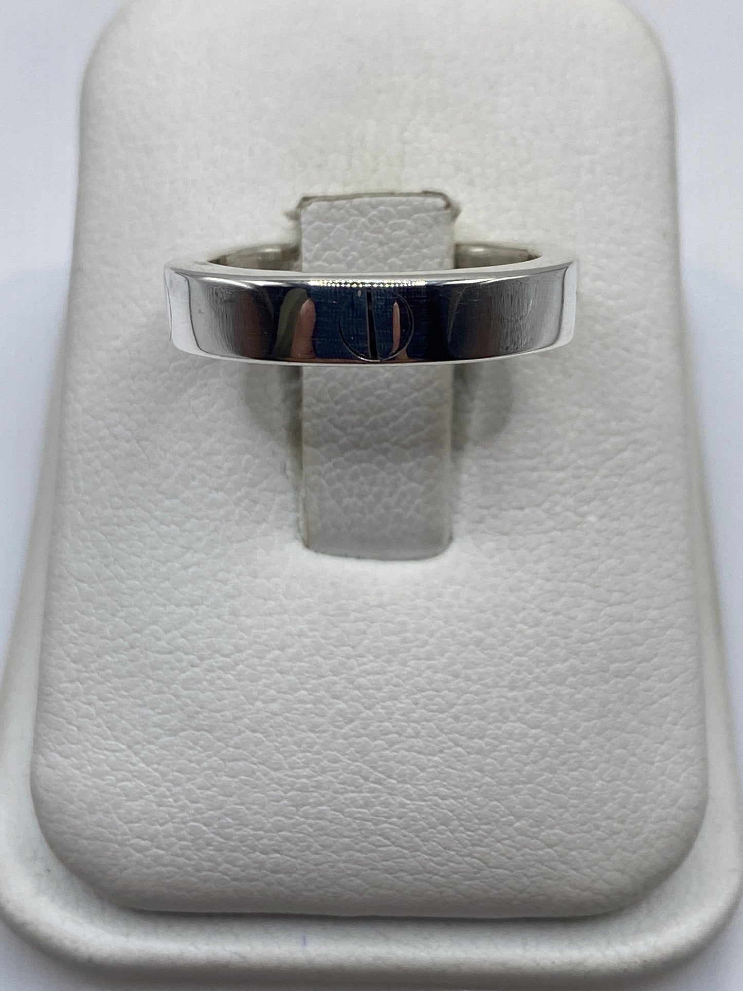 Anillo de plata sello minimalista en display blanco, vista frontal del sello grabado