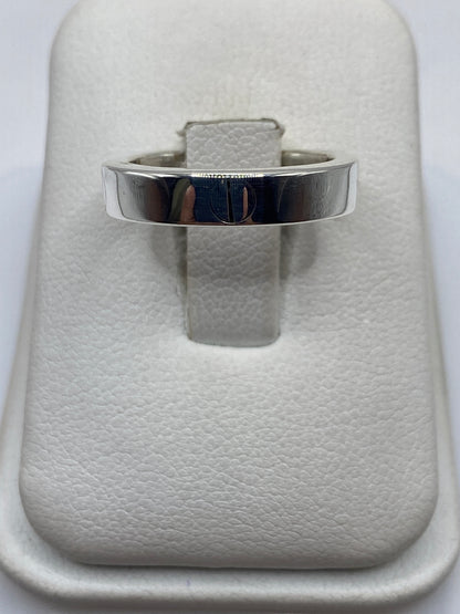 Anillo de plata sello minimalista en display blanco, vista frontal del sello grabado