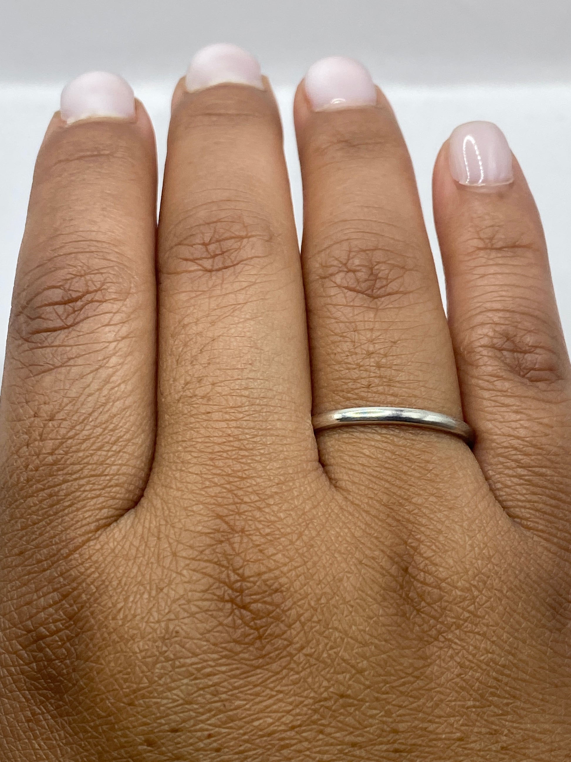 Anillo minimalista puesto en dedo de mujer mostrando presencia delicada