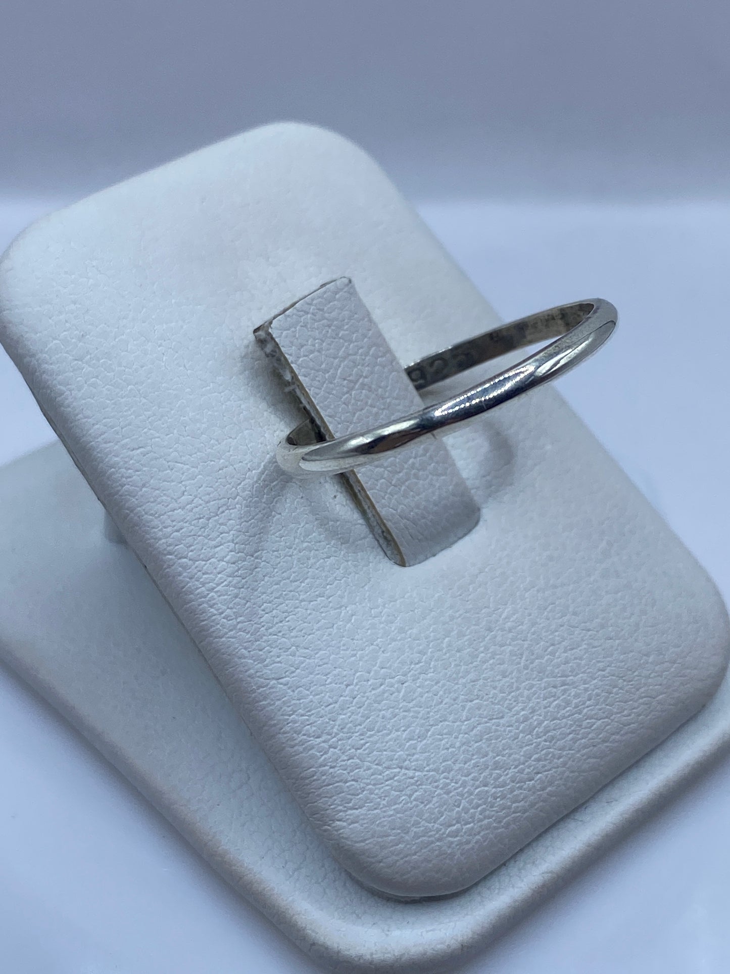 Anillo minimalista de plata en dedo, mostrando el brillo pulido