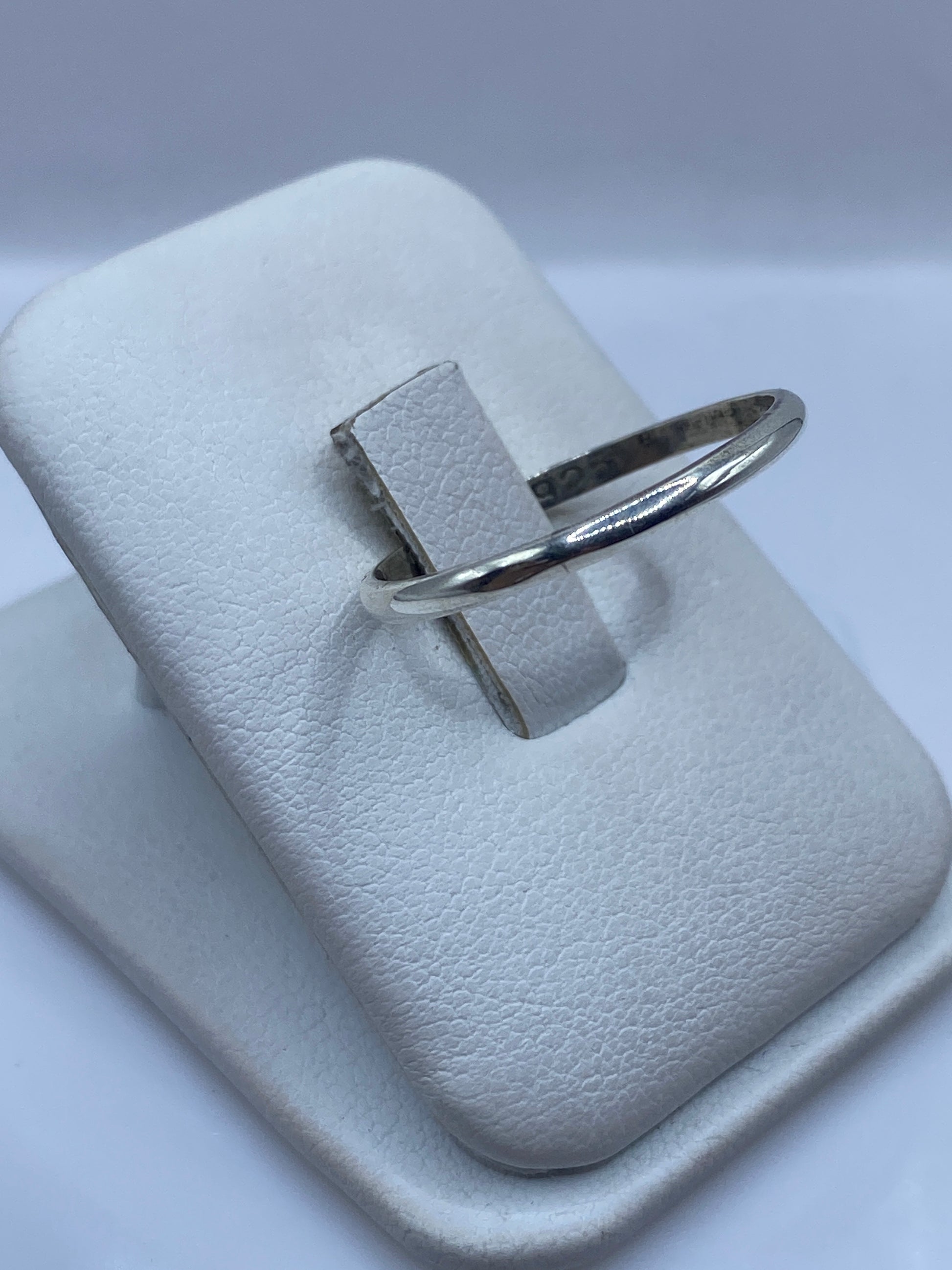 Anillo minimalista de plata en dedo, mostrando el brillo pulido