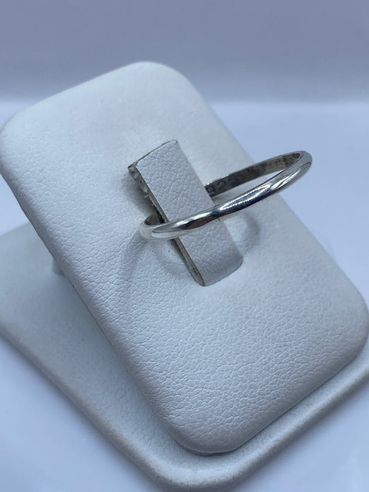 Anillo minimalista de plata en dedo, mostrando el brillo pulido