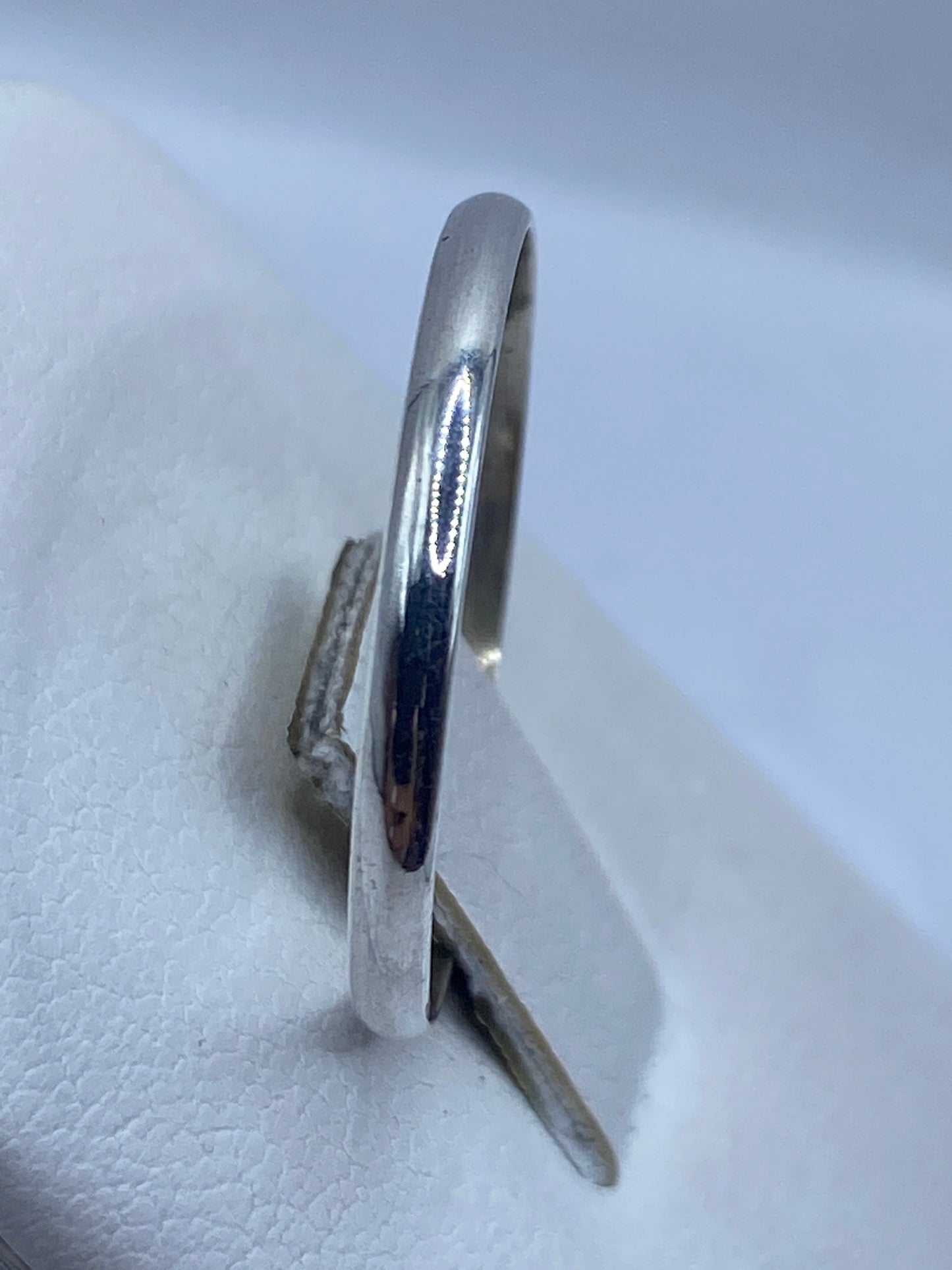 Detalle lateral del anillo banda pulido, reflejando luz como espejo