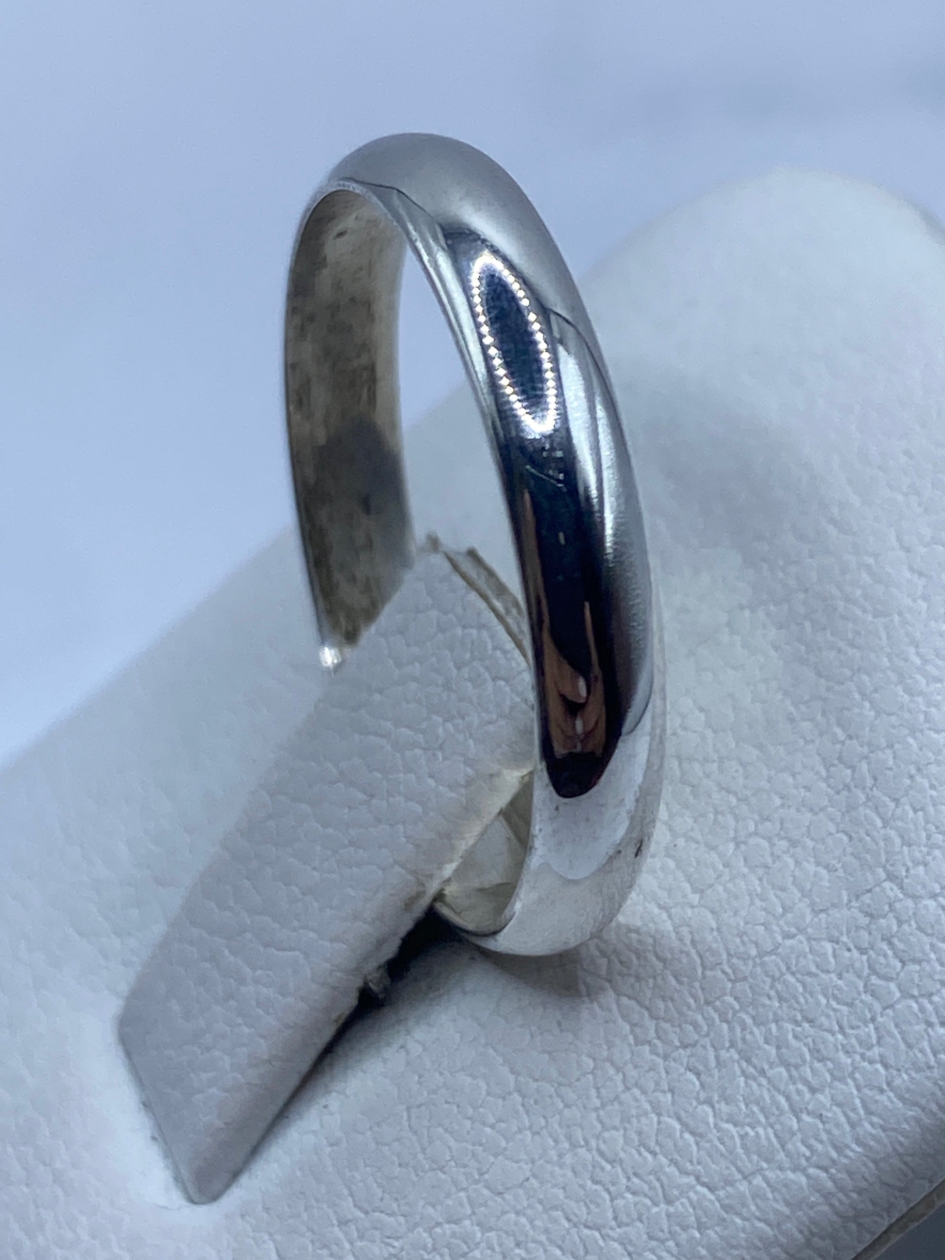 Anillo de banda lisa de plata en dedo, demostrando comodidad de uso diario
