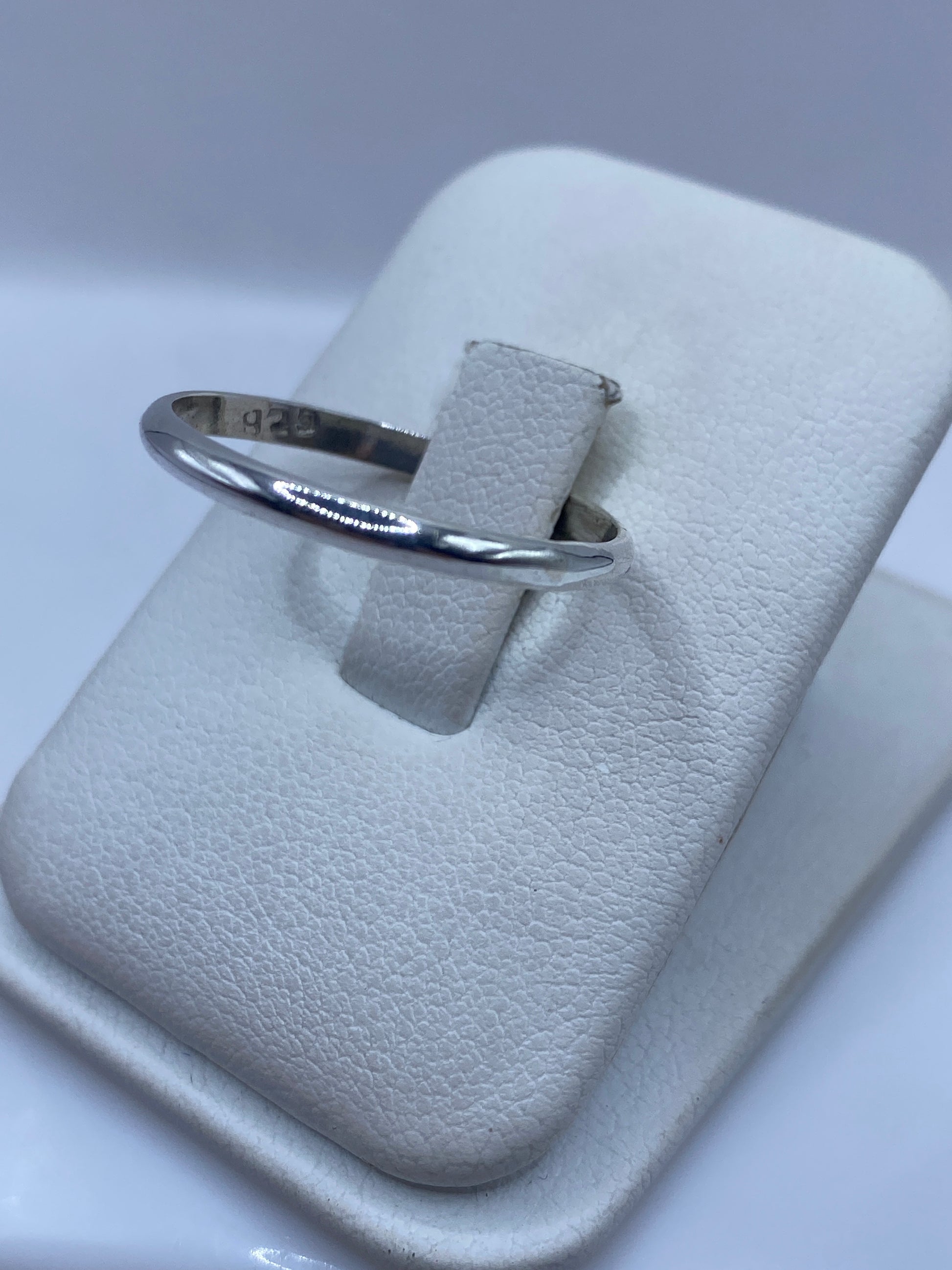 Anillo minimalista de plata en mano de mujer, detalle de brillo