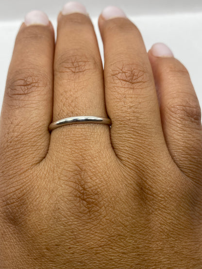 Anillo banda lisa de plata sobre superficie neutra, perfil