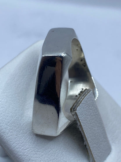 Anillo minimalista de plata en la mano mostrando el acabado pulido preciso