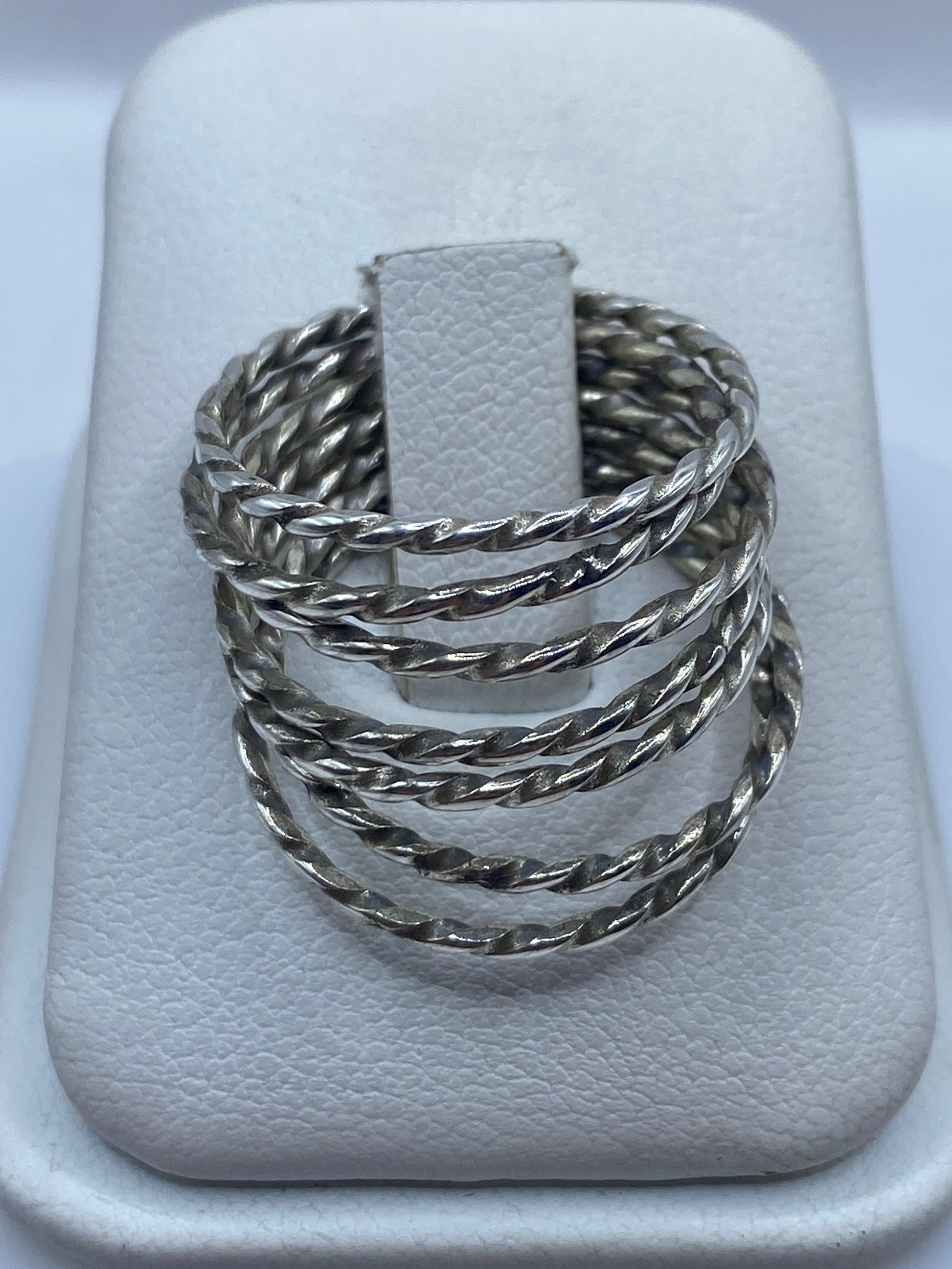 Anillo de plata con eslabones retorcidos tejidos a mano, mostrado en dedo
