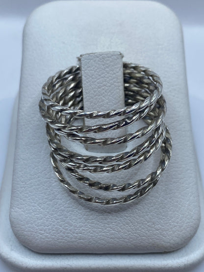 Anillo de plata con eslabones retorcidos tejidos a mano, mostrado en dedo