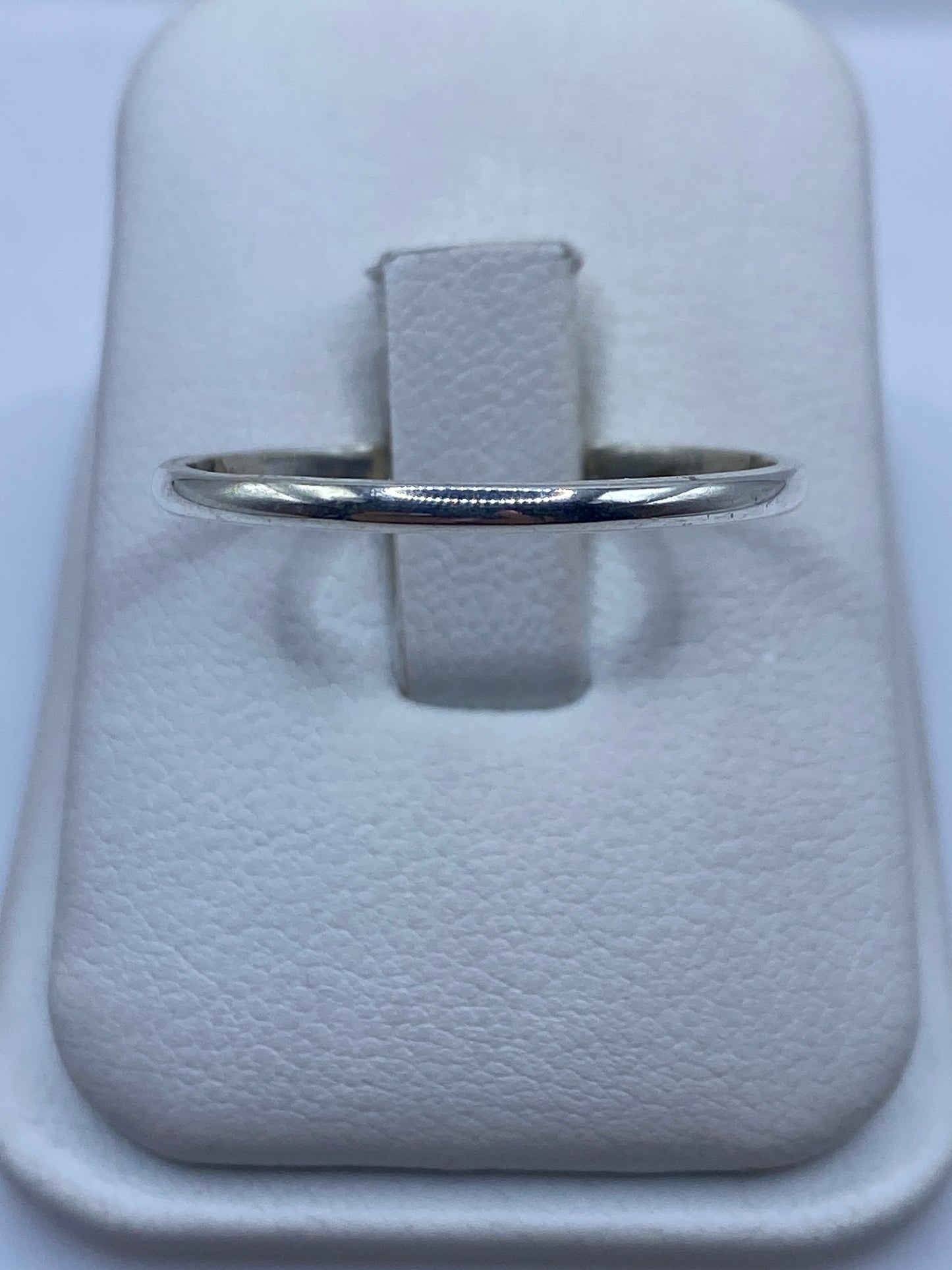 Anillo de plata banda minimalista pulida en dedo femenino