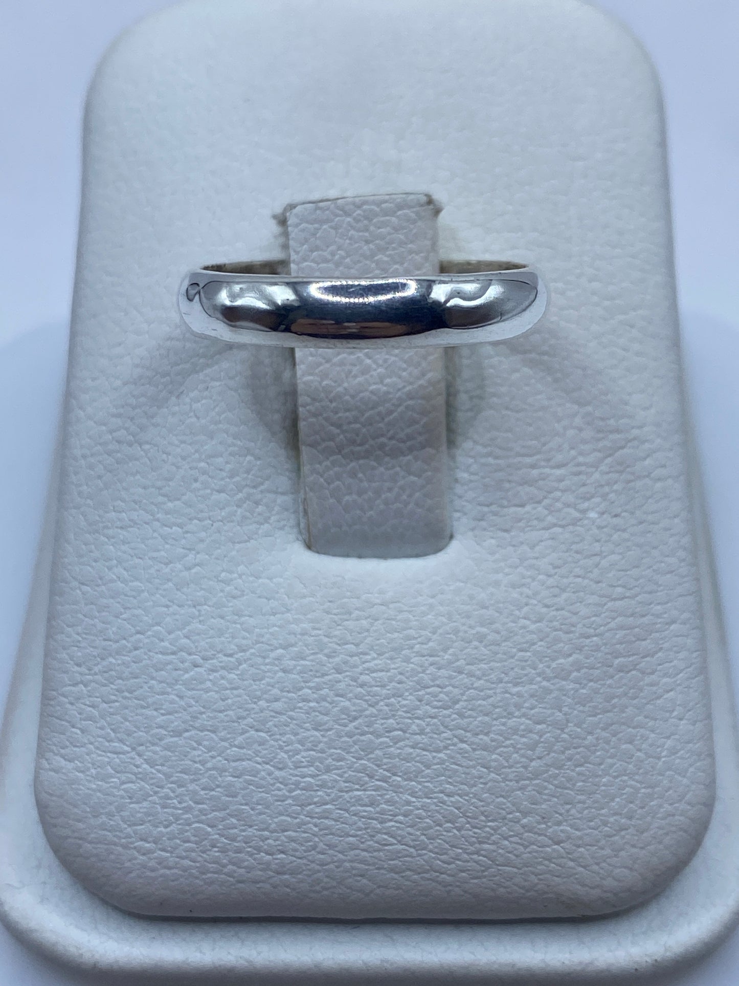 Anillo de plata banda pulida en estuche blanco, vista frontal