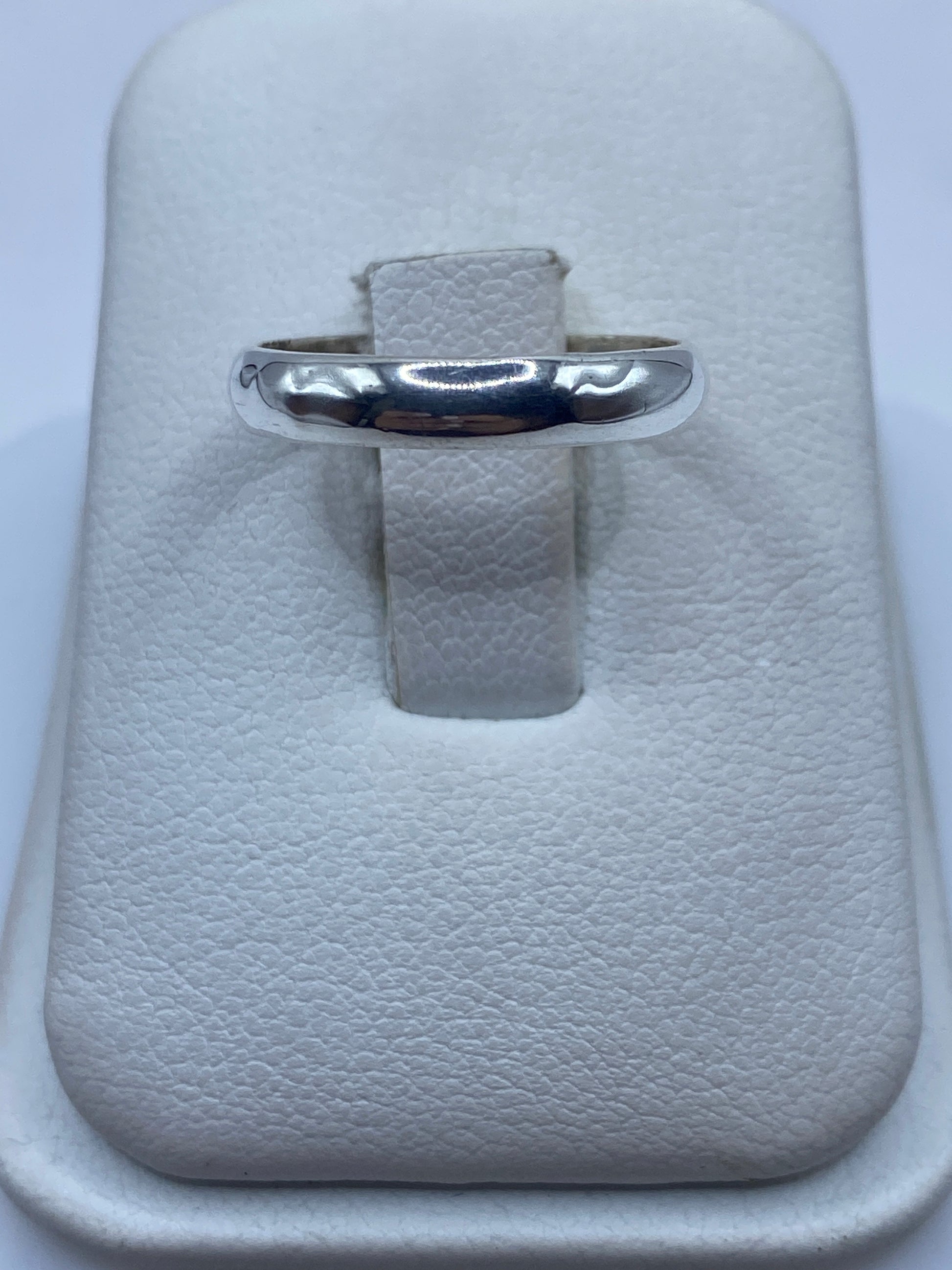 Anillo de plata banda pulida en estuche blanco, vista frontal
