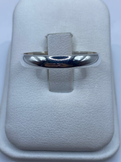 Anillo de plata banda pulida minimalista en mano de mujer